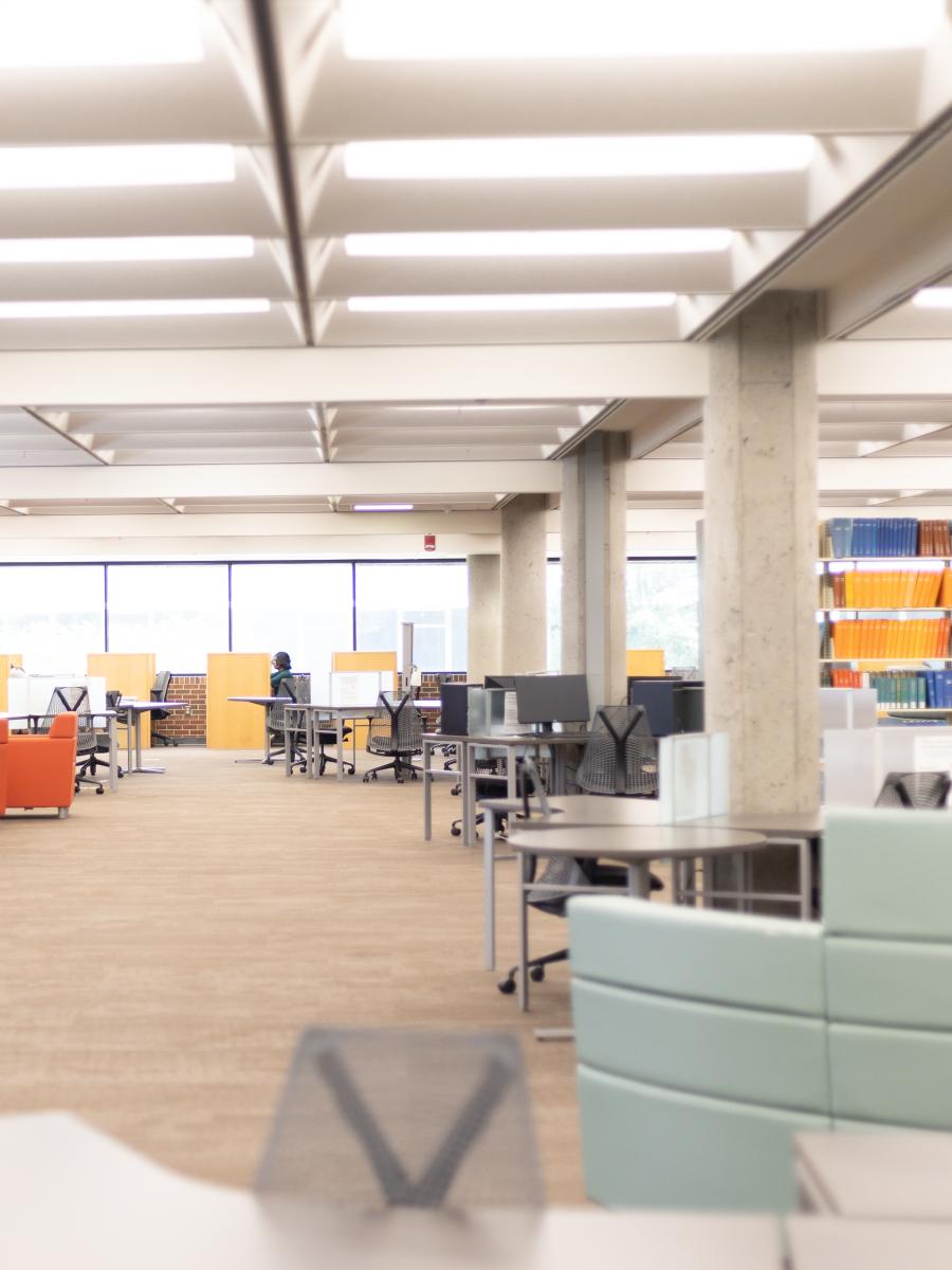 Random chairs and table in front of shelved journals