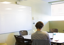 One person sitting at a large table studying in a room