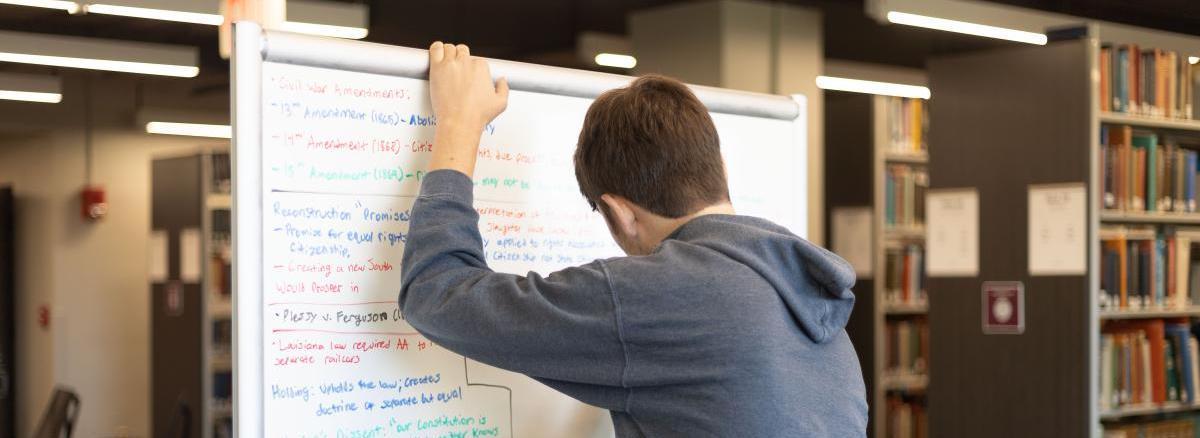 student writing on white board