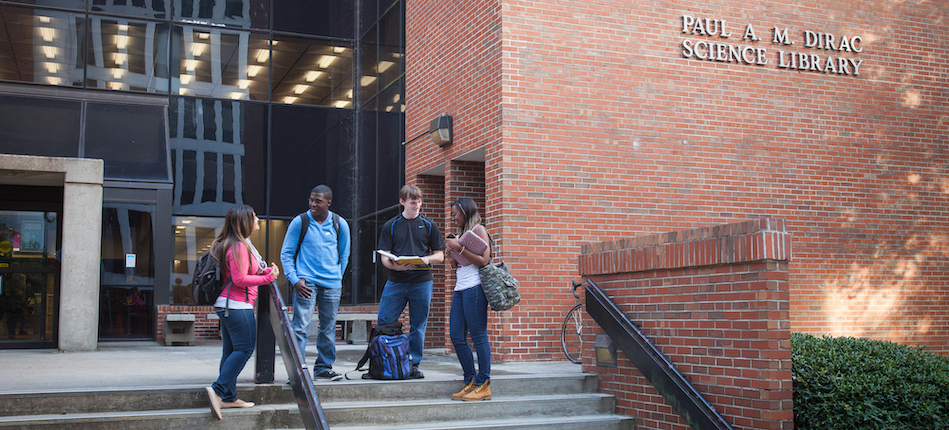 Three students standing on the steps of Paul Dirac Science Library