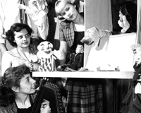 black and white photo of women at a puppet show