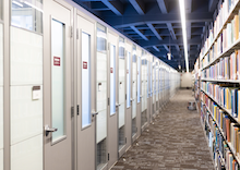 Walkway between row of doors and shelves filled with books